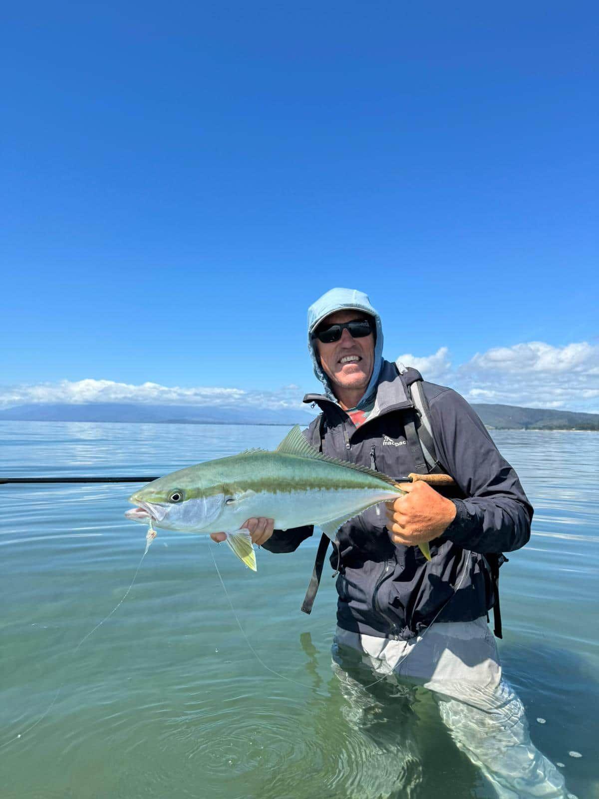 Holding up a fish caught in the shallows