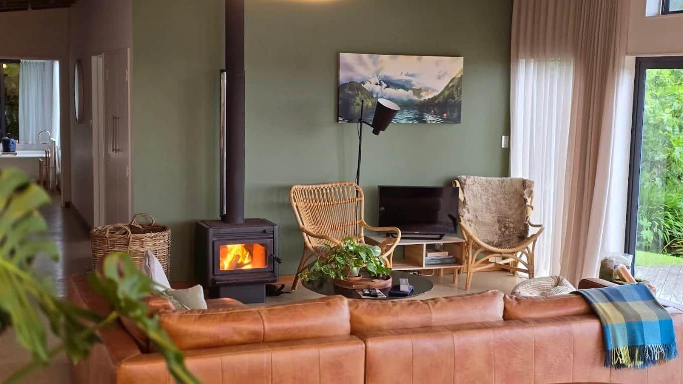Lounge with wood burner, leather sofa and bush views
